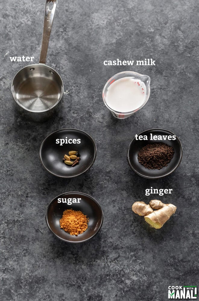 small bowls filled with spices, tea leaves, sugar and a measuring cup with milk and water