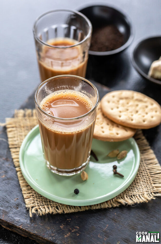 glass filled with chai and 2 cookies placed on the side