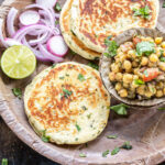 bread kulcha served with a bowl of matar chaat, sliced onion and a round of lemon in a pattal
