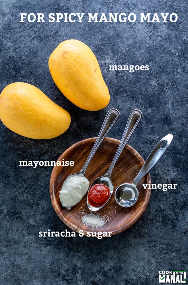 2 mangoes with spoons filled with mayonnaise, hot sauce, vinegar