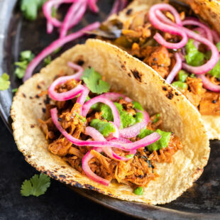 tacos filled with jackfruit and topped with pickled onion and cilantro chutney