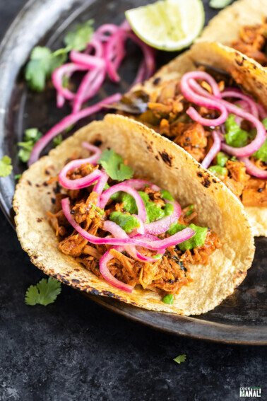tacos filled with jackfruit and topped with pickled onion and cilantro chutney