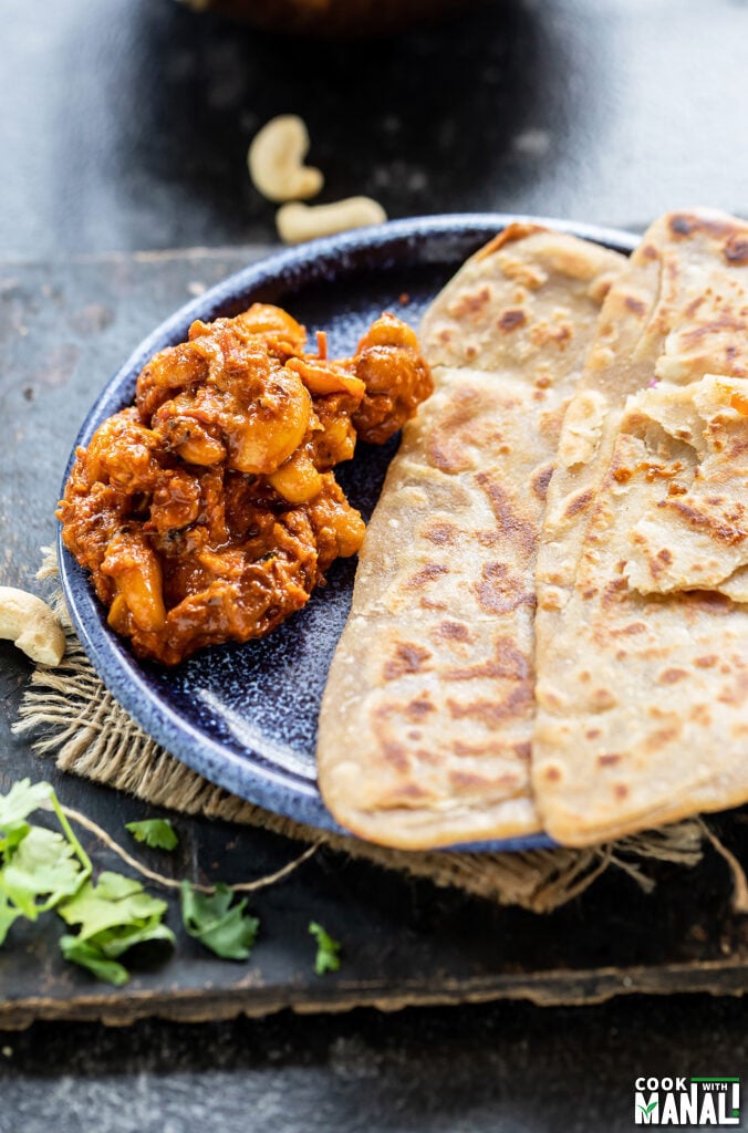 cashew curry served with parathas on a plate