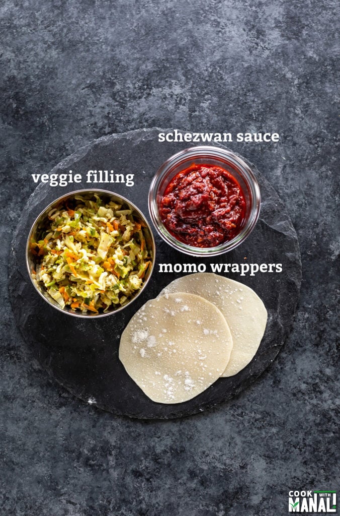 dumpling wrappers, bowl of veggies and a bowl of sauce arranged on a board