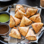 samosa arranged on a plate lined with newspaper