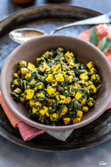 paneer and spinach stir fry served in a brown color bowl
