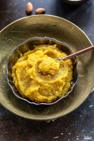 almond halwa served in a bowl garnished with saffron strands