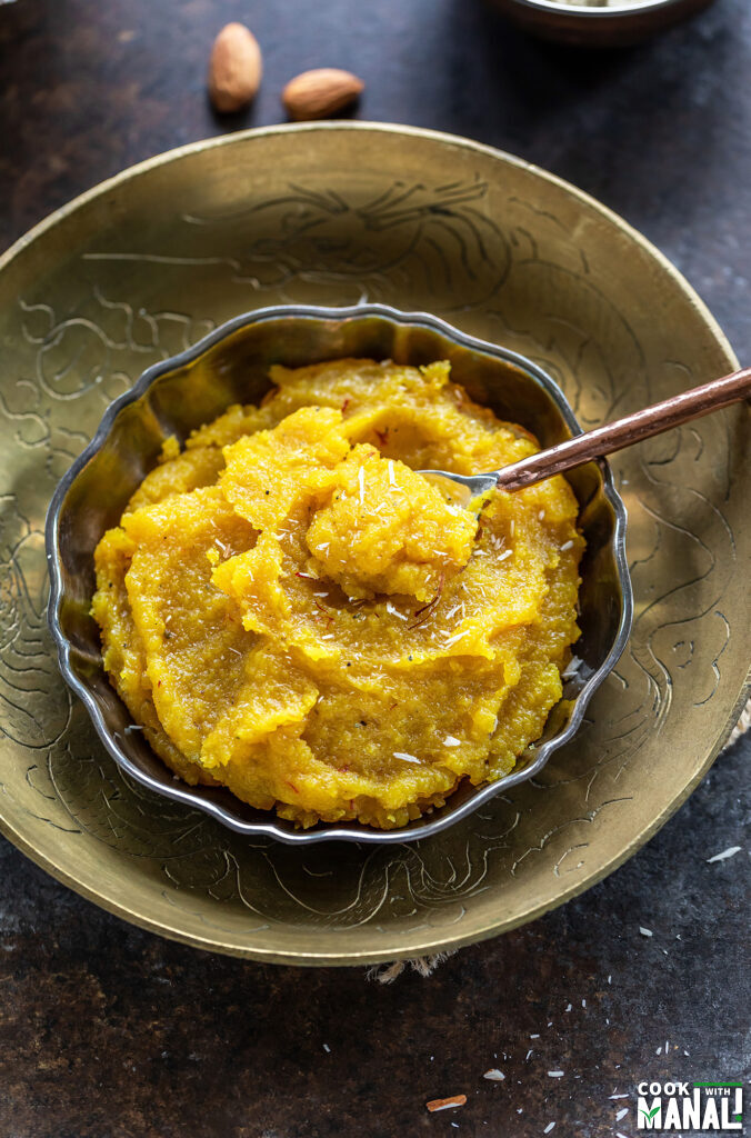 almond halwa served in a bowl garnished with saffron strands