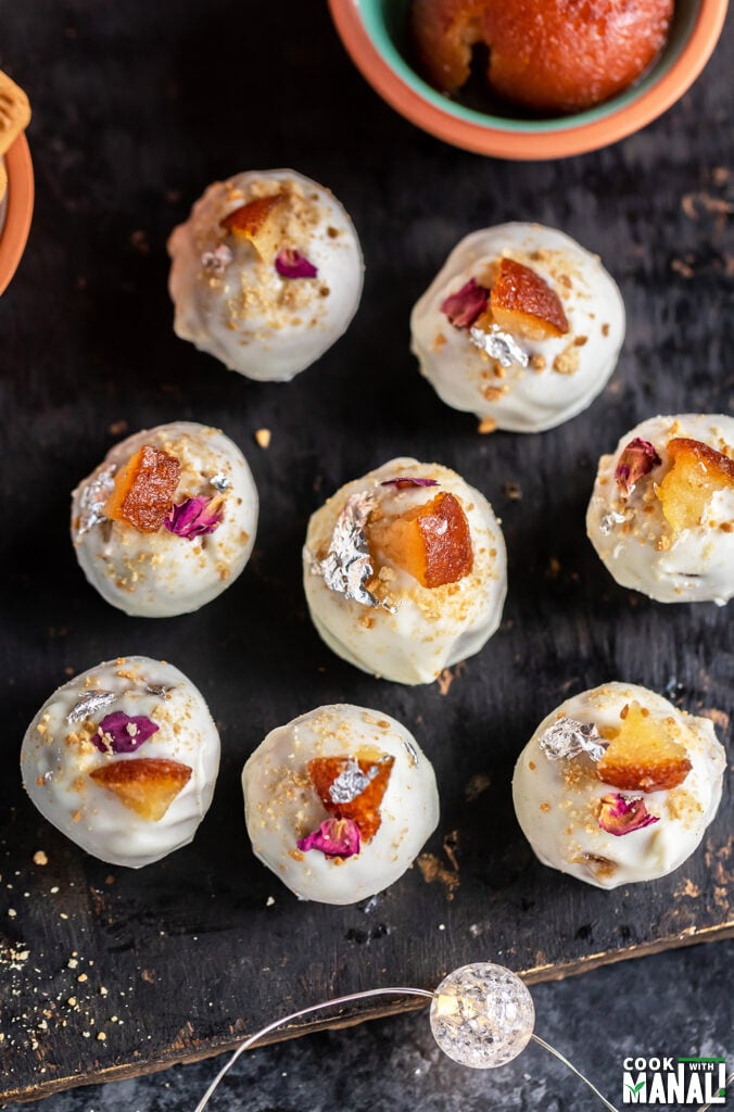 overhead shot of gulab jamun cheesecake truffles arranged on a board