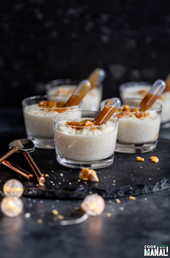 rice pudding kheer served in a short dessert glasses with caramel sauce filled cupcake pipettes