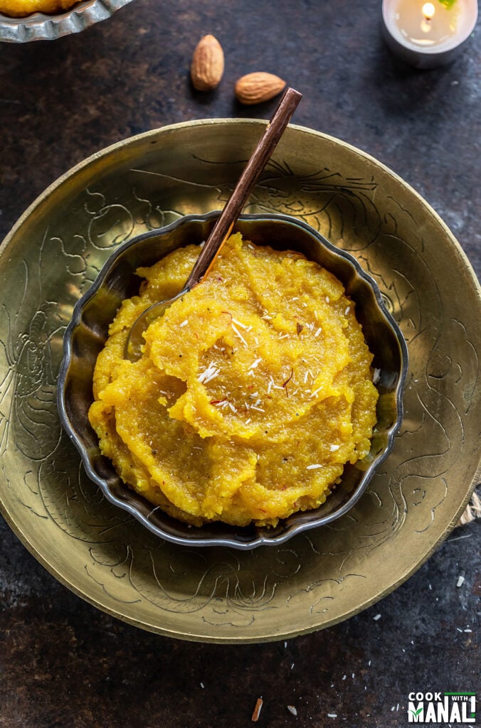 almond halwa served in a bowl garnished with saffron strands