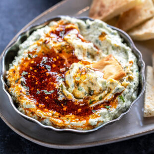 whipped paneer dip served in a antique bowl topped with honey and chopped mint
