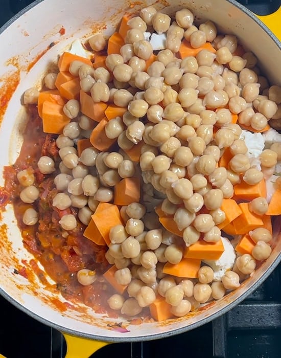 chickpeas, sweet potato cubes in a pot of curry