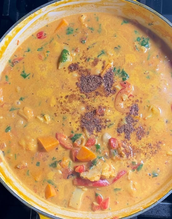pot of curry topped with garam masala simmering in a pot