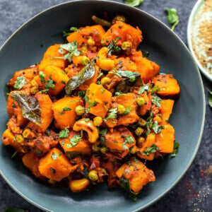 butternut squash cooked with spices and garnished with cilantro served in a bowl