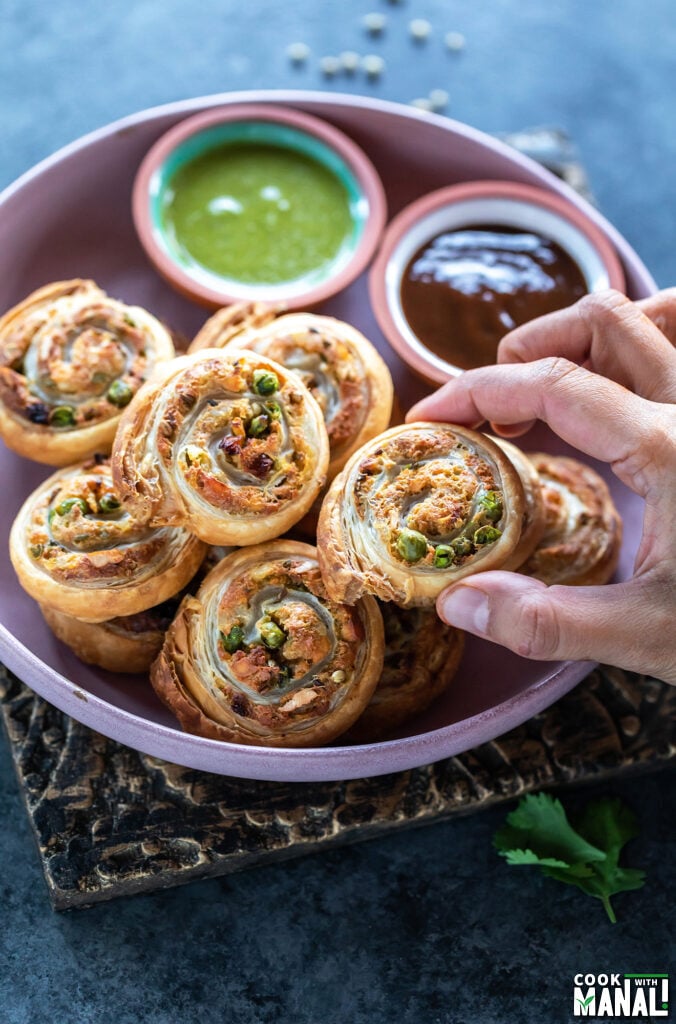 hand holding a pinwheel samosa in hand