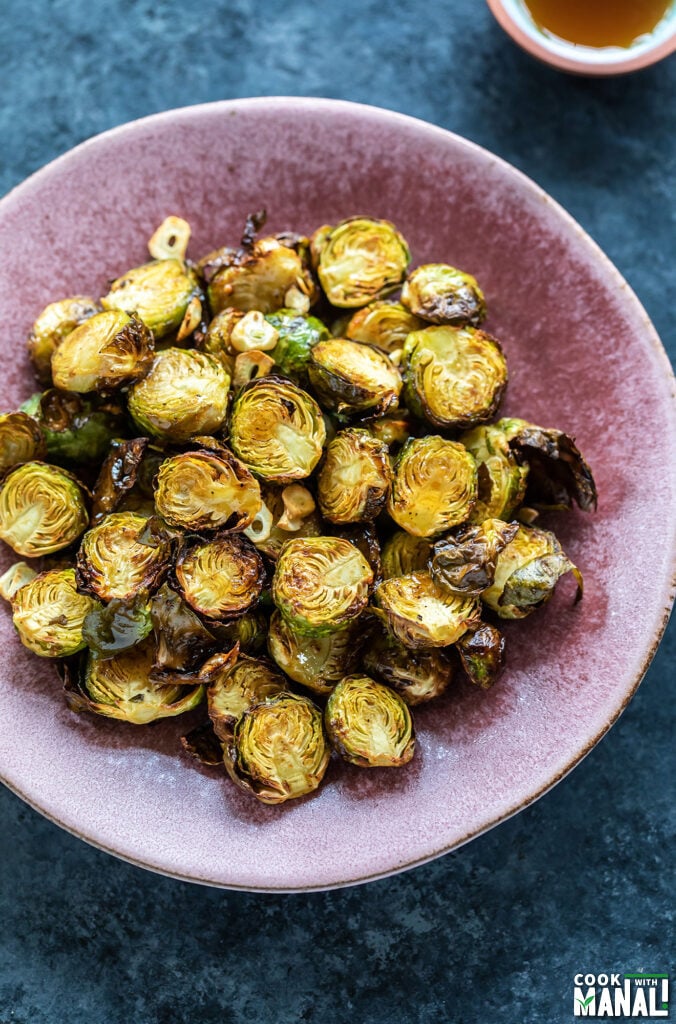 roasted brussel sprouts served in a pink color plate