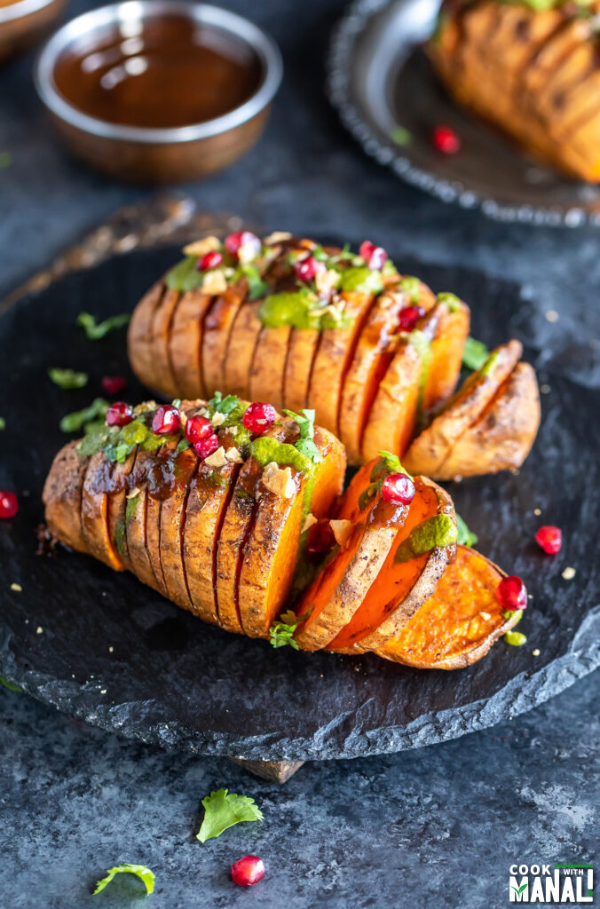hasselback potatoes sliced into thick slices and drizzled with chutneys and topped with cilantro, mint and pomegranate