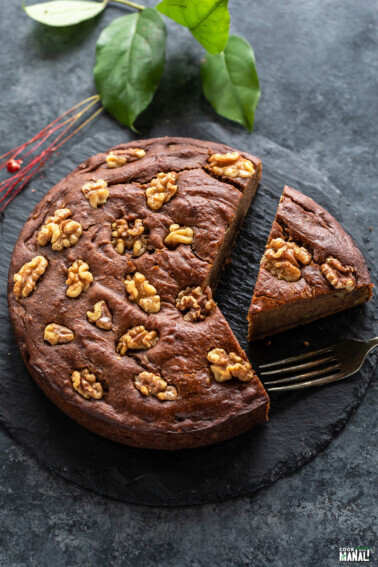 a slice of date walnut cake cut from the cake and placed on a serving board