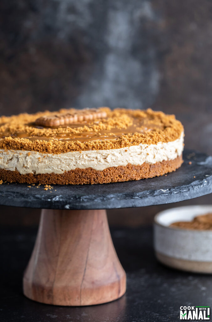 biscoff cheesecake on a black cake stand