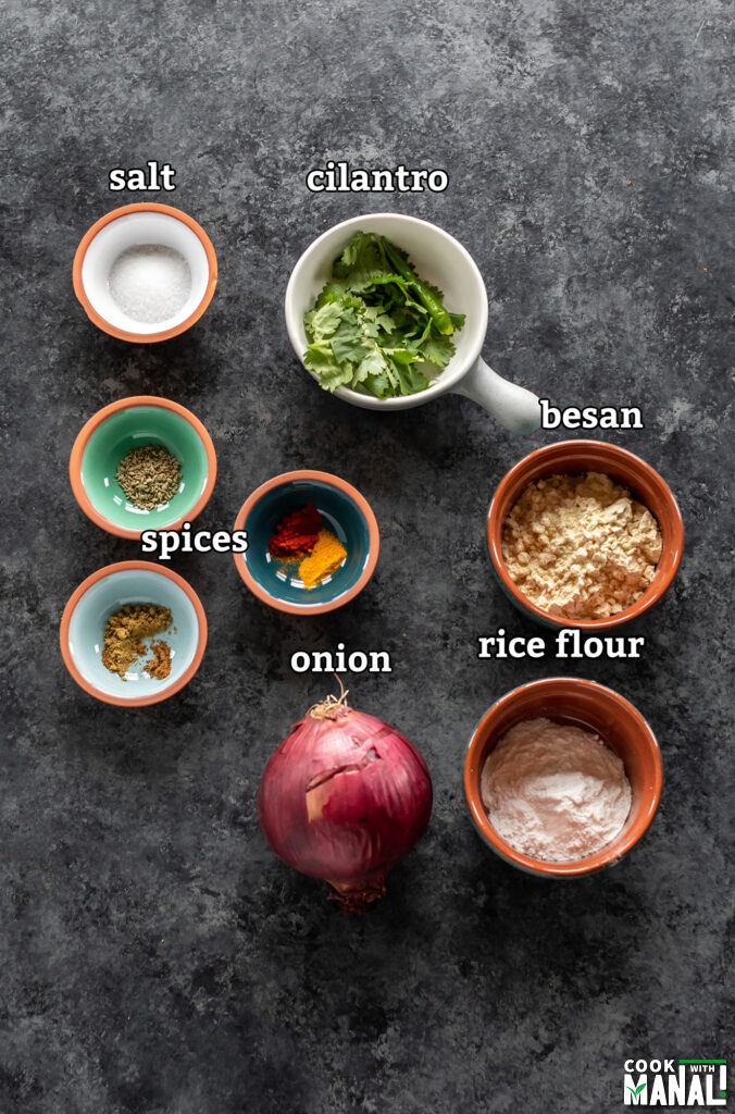 ingredients for onion pakoda arranged on a board