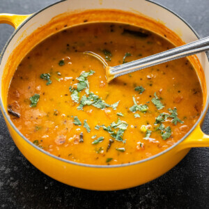 dal in a yellow color pot with ladle and garnished with cilantro