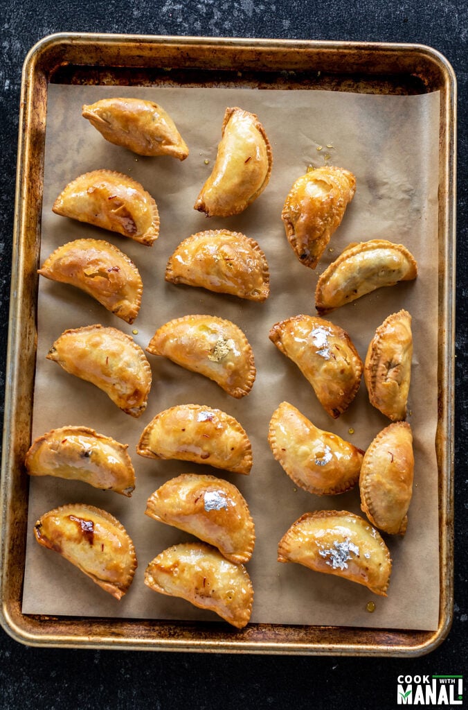 gujiyas arranged on a baking tray