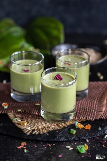 green color drink served in shot glasses garnished with rose petals