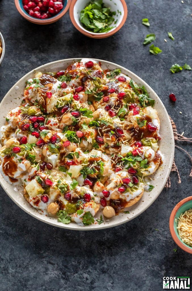 plate of papdi chaat garnished with cilantro, pomegranate, sev