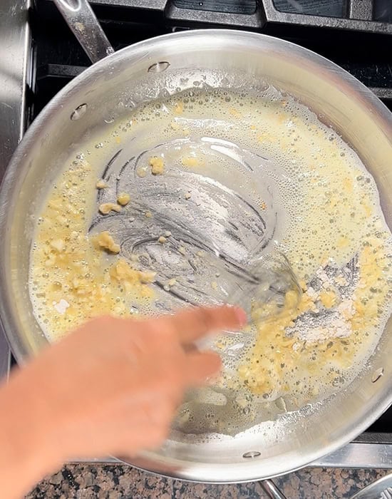 whishing flour with butter in a pan with a whisk