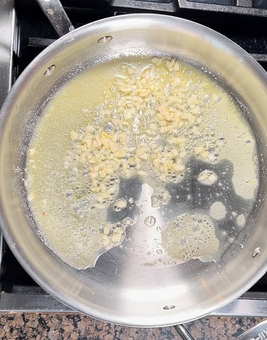 chopped garlic with butter in a steel pot