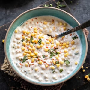 yogurt in a blue bowl topped with boondi and chopped mint