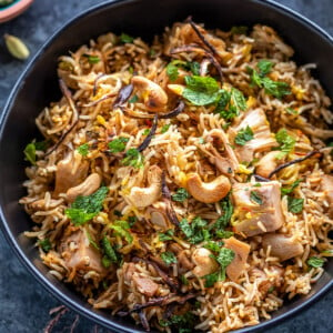 jackfruit biryani served in a black bowl garnished with mint leaves and fried onions