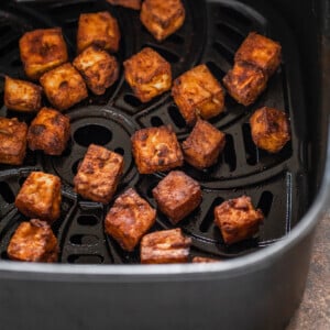 crispy tofu arranged in an air fryer basket