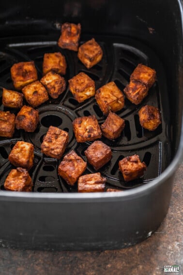 crispy tofu arranged in an air fryer basket