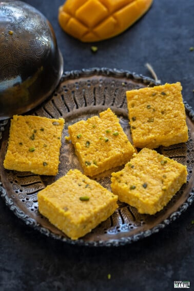 5 pieces of mango kalakand placed on an antique looking plate