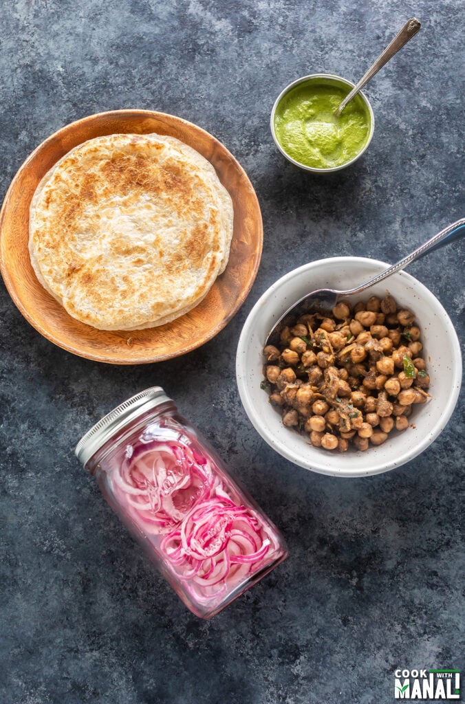ingredients for making chana kathi roll arranged on a board