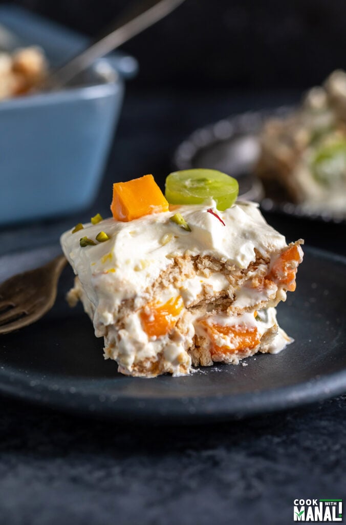 piece of icebox cake showing layers of cream, fresh fruits and cookies