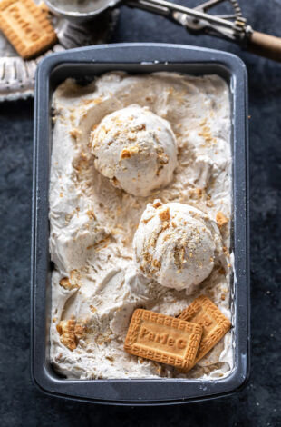 scoops of ice cream in a container with 2 parle-g biscuits placed on one side