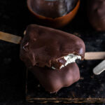 two choco bar ice creams on top of each other with top one revealing the inner vanilla ice cream