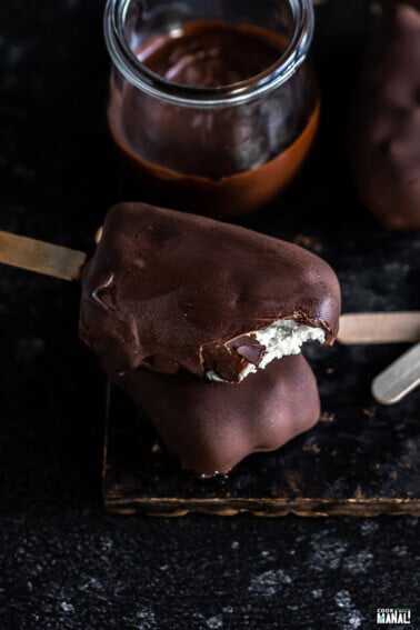 two choco bar ice creams on top of each other with top one revealing the inner vanilla ice cream