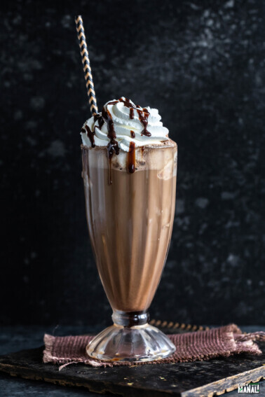 iced mocha served in a tall glass garnished with whipped cream and chocolate syrup