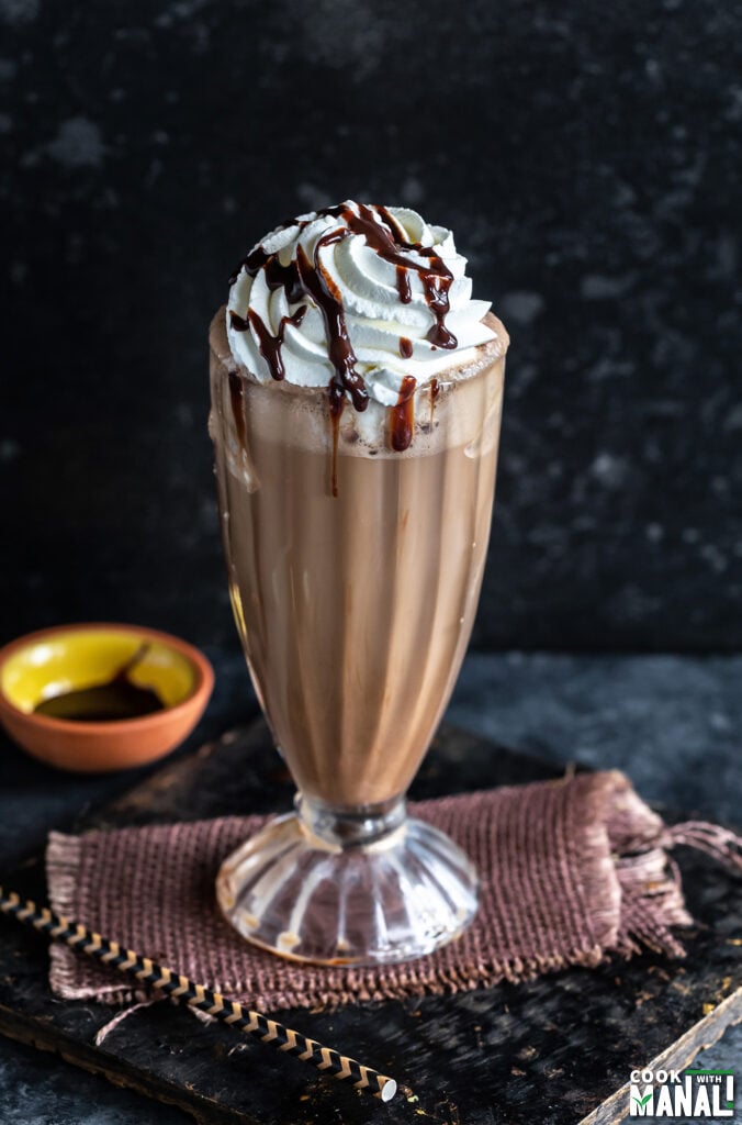 iced mocha served in a tall glass garnished with whipped cream and chocolate syrup
