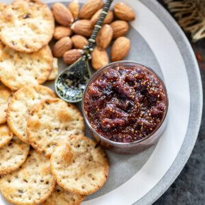fig chutney served in a small bowl with crackers and almonds on the side