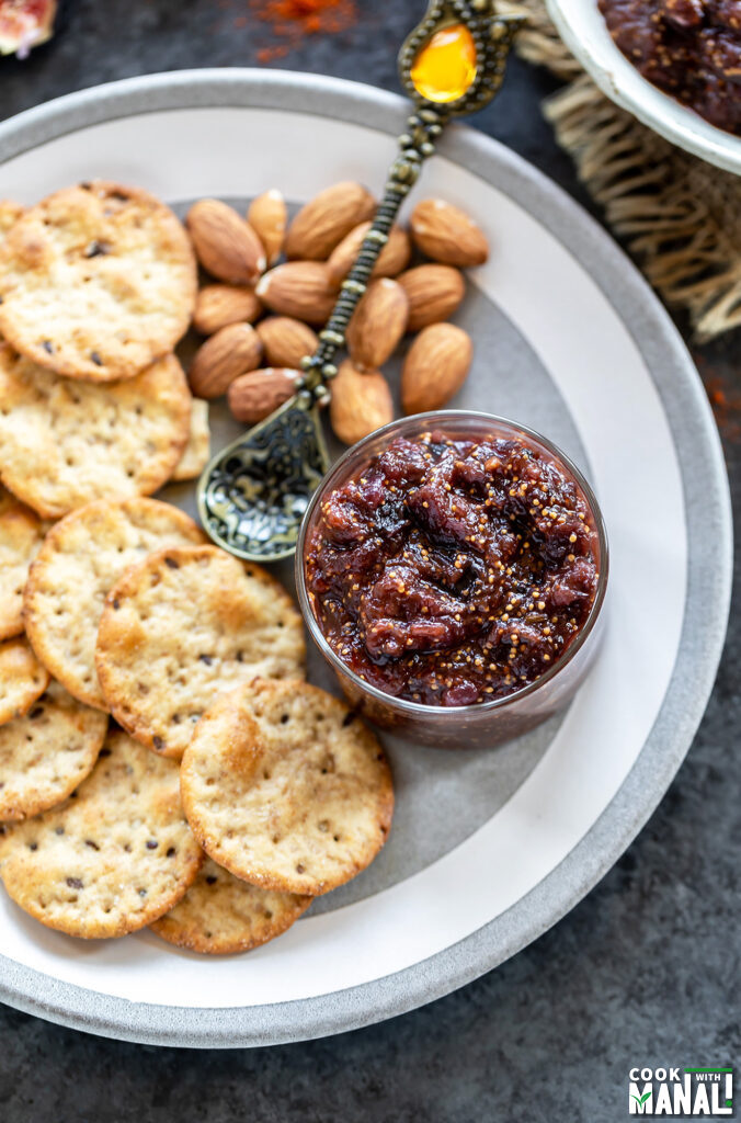 fig chutney served in a small bowl with crackers and almonds on the side