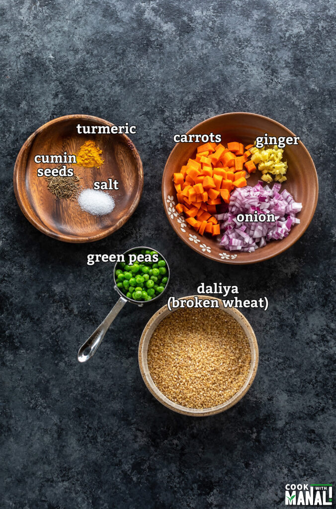 ingredients for making vegetable daliya arranged on a board