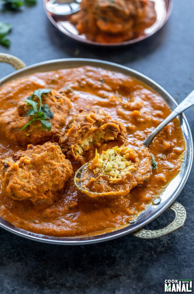 lauki kofta curry served in a copper dish with one kofta cut to show the inside