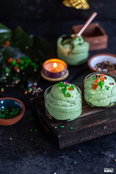 2 short glasses filled with paan mousse with a tealight placed in the background