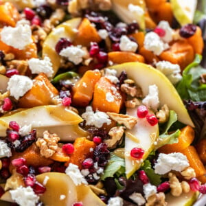 butternut squash salad with pears, goat cheese, pomegranate arranged on a plate