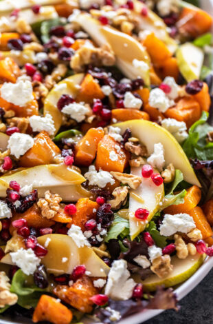 butternut squash salad with pears, goat cheese, pomegranate arranged on a plate
